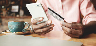 A man checking on the phone using a credit card