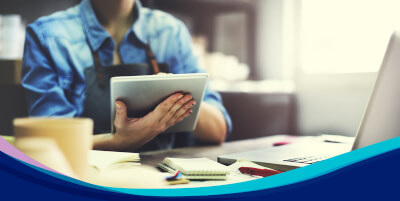 Person working on their mobile device and laptop