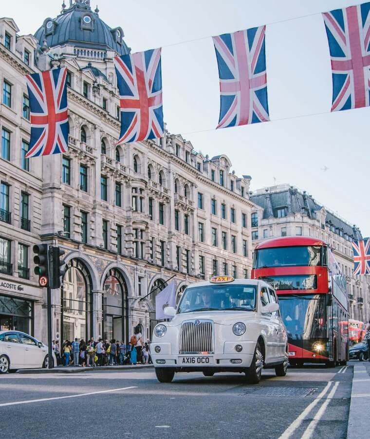 Union jack flags suspended across Oxford street with cars and buses passing by