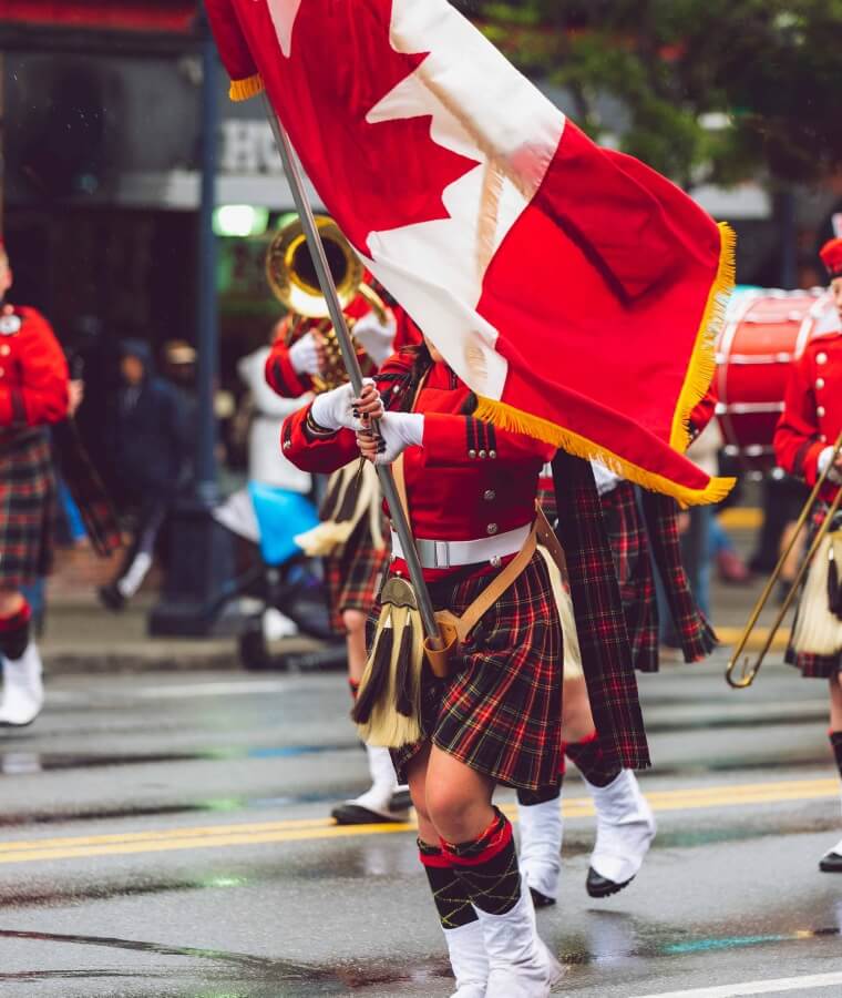 A girl carrying a Canadian flag on a parade